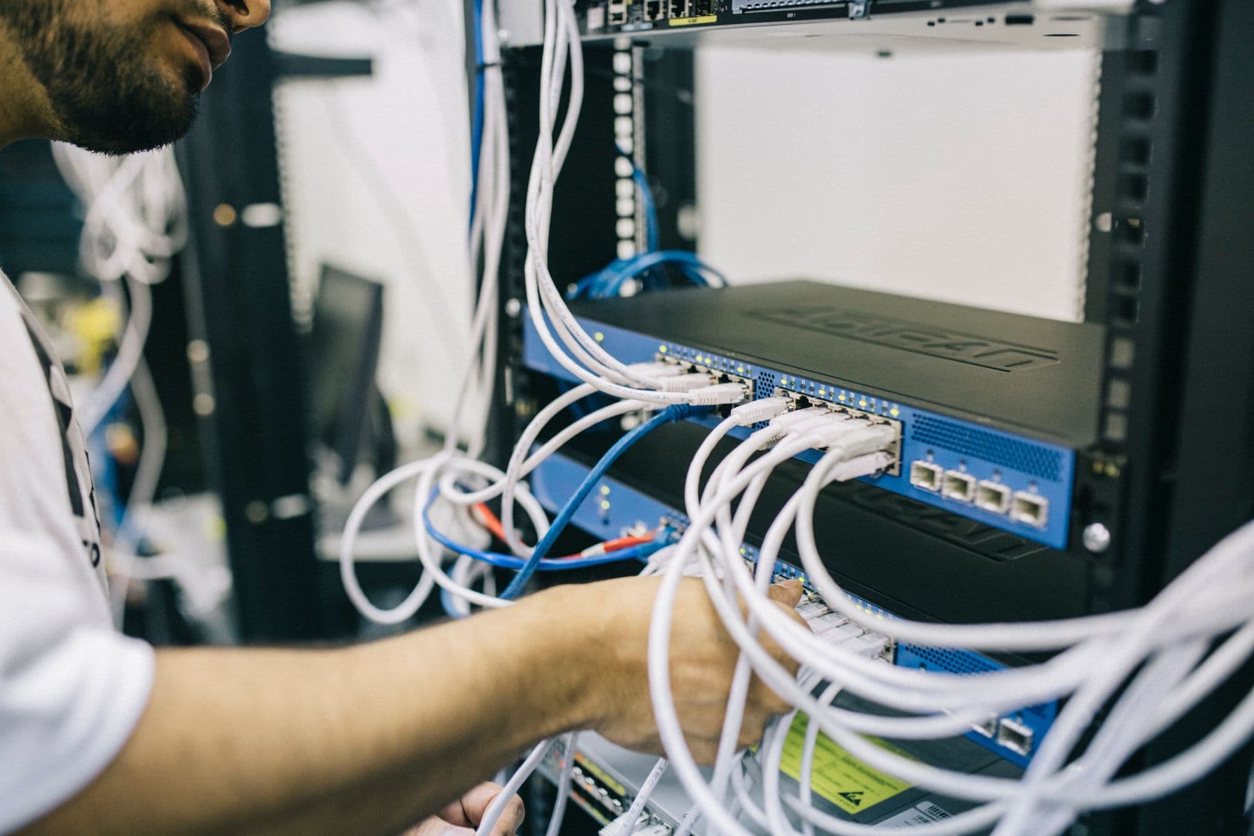Especialista conectando cableado en un gabinete de red